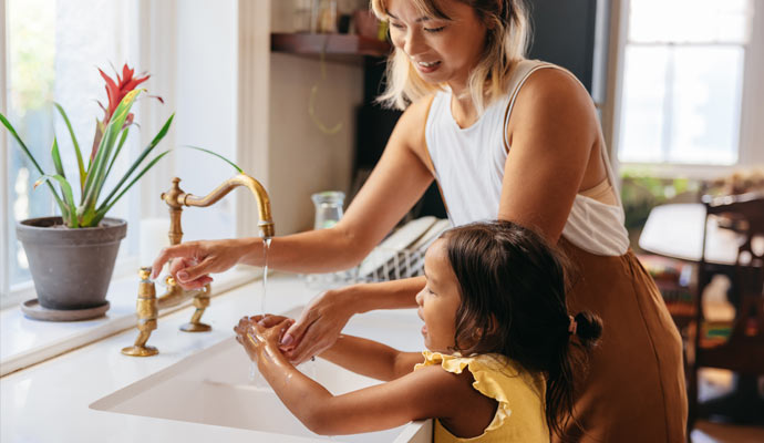 Women and his kids cleaning hand on cleaned kitchen sink